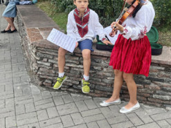 Маленькі кияни збирають гроші для ЗСУ: молодший брат тримає ноти для сестрички, яка грає на скрипці