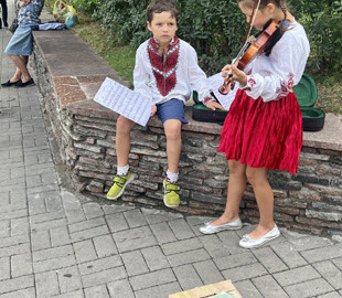 Маленькі кияни збирають гроші для ЗСУ: молодший брат тримає ноти для сестрички, яка грає на скрипці