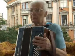 У центрі Києва 76-річна бабуся розважає містян грою на баяні зі свого балкона