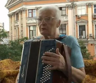 У центрі Києва 76-річна бабуся розважає містян грою на баяні зі свого балкона